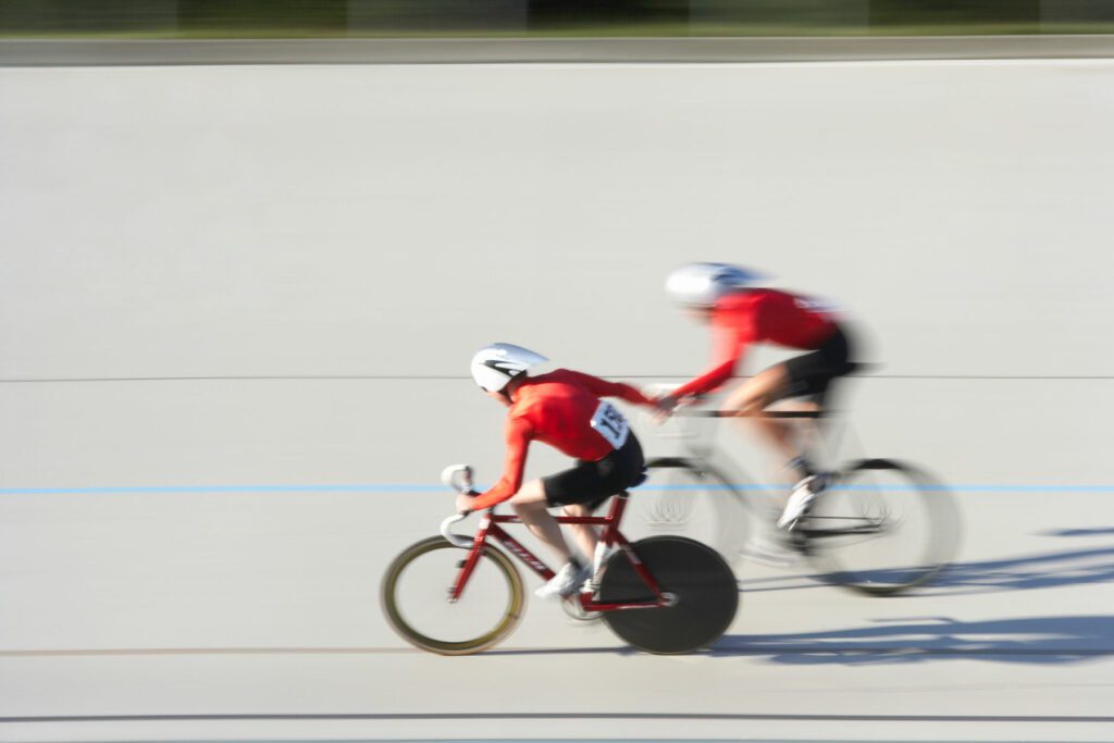 Two cyclists in action on velodrome track