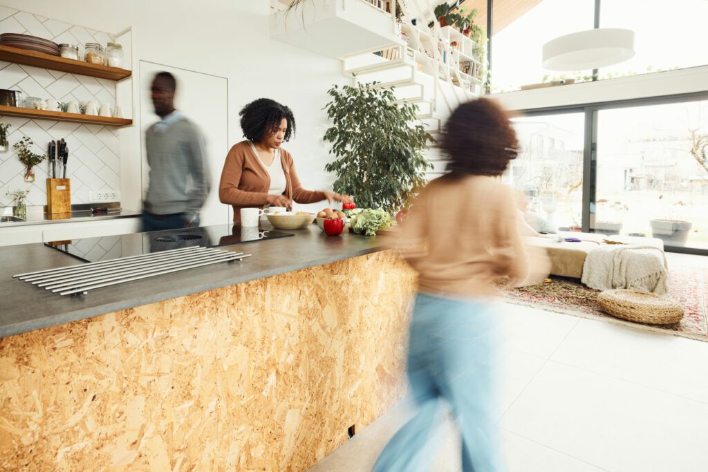 Black woman preparing food around her family in blurred motion