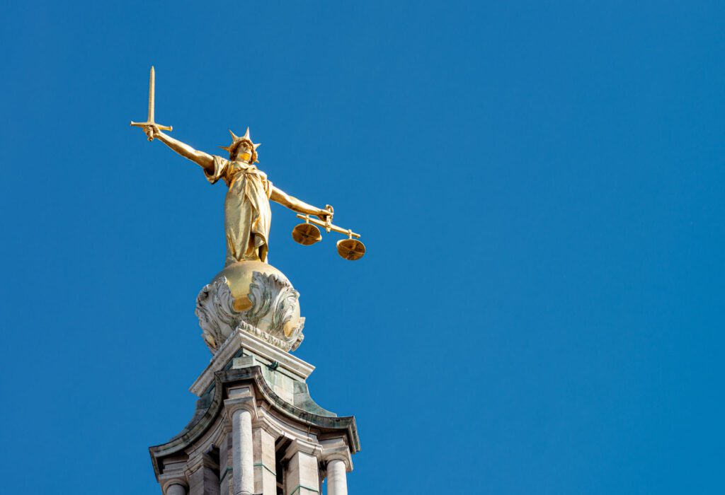 A statue of Lady Justice holding a sword and balancing scales, on top of the Old Bailey, England's criminal court in the City of London