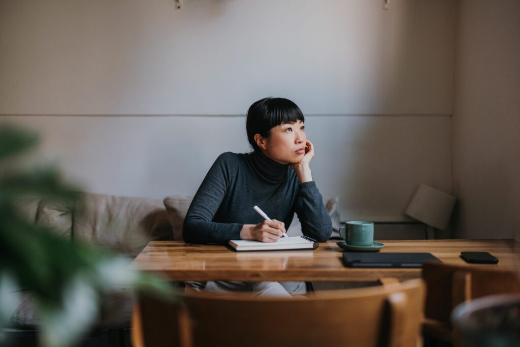 Women working from home looking out contemplatively