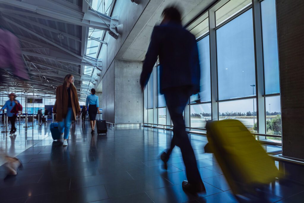 Blurred motion of person wheeling suitcase through an airport