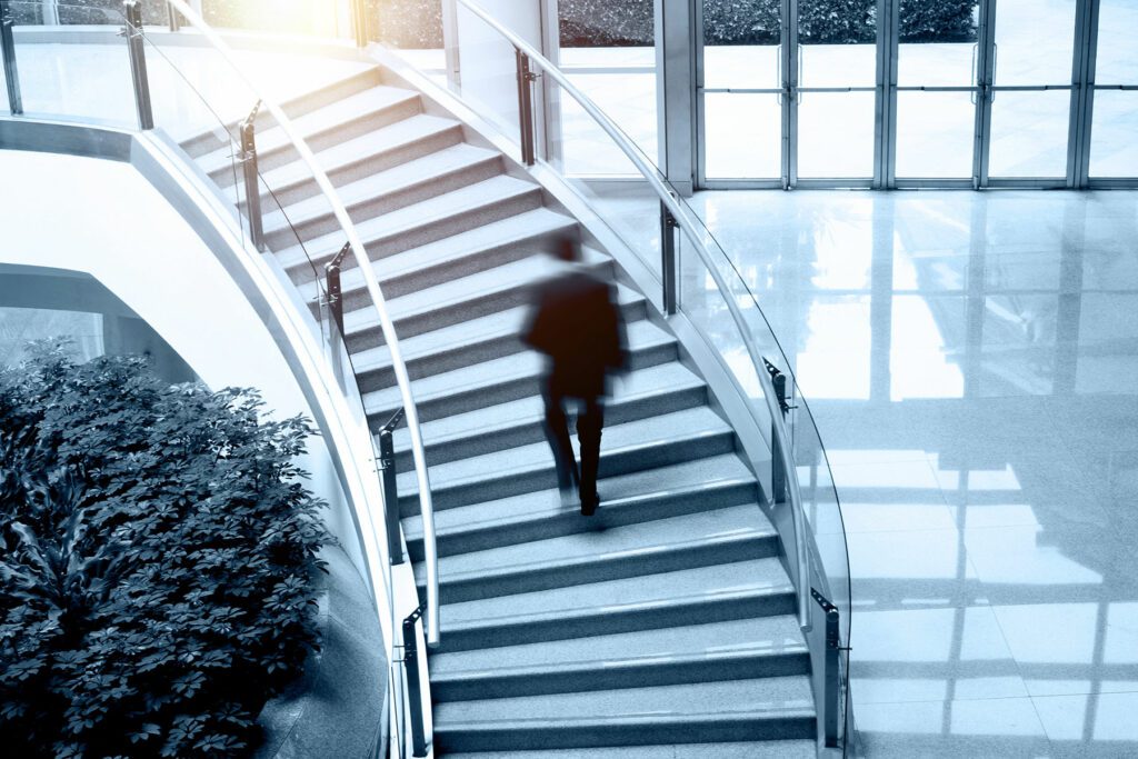 Man walking up stairs in office building