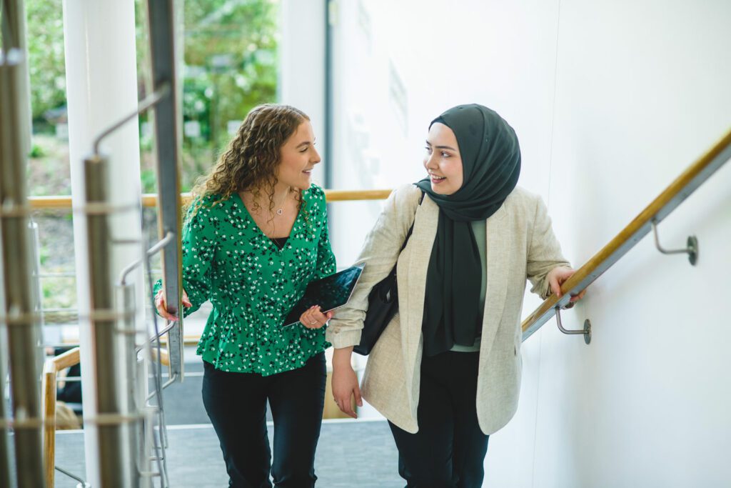 Two women walking upstairs in Michelmores office