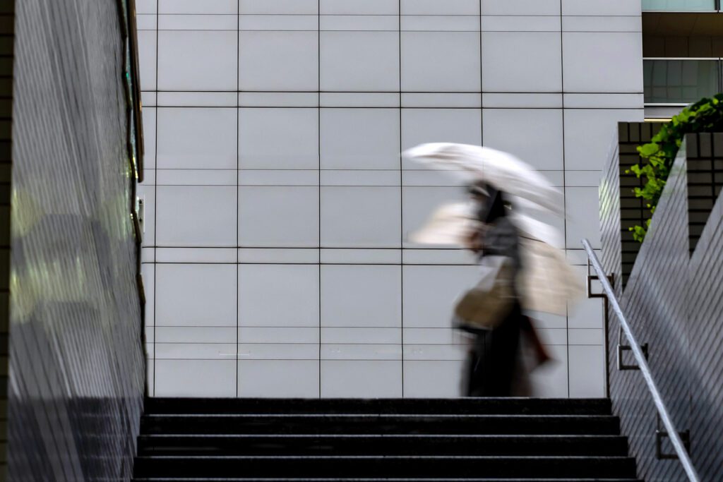 Person walking with umbrella through a street