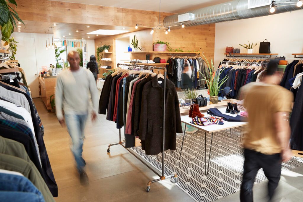 People walking through a busy clothes shop