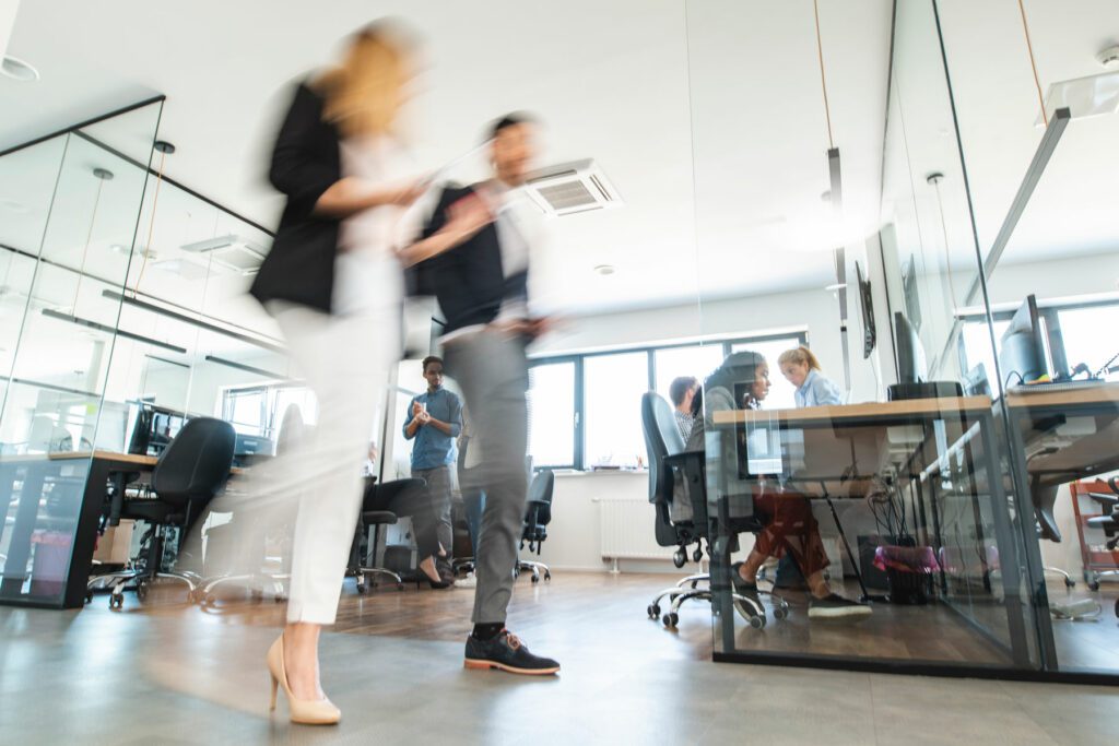 Young Business Colleagues Walking Through Open Plan Office