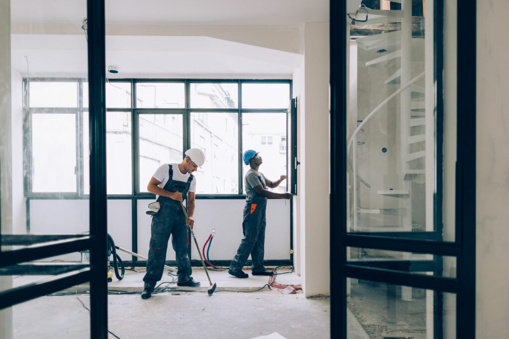 Two Construction Workers Working Together on an Apartment Renovation