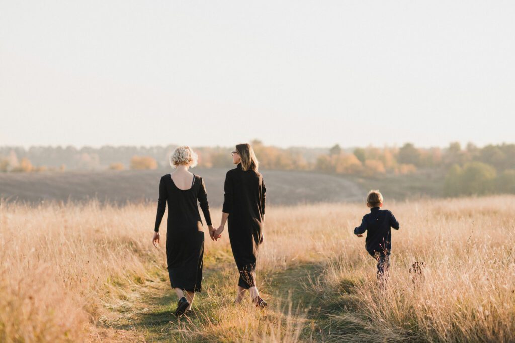 Lesbian couple with their young son enjoying a day in a field