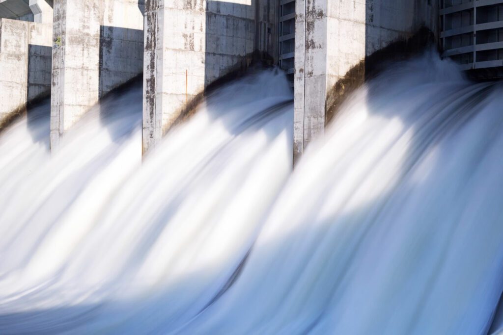 Water in long exposure rushing out of open gates of a hydro electric power station