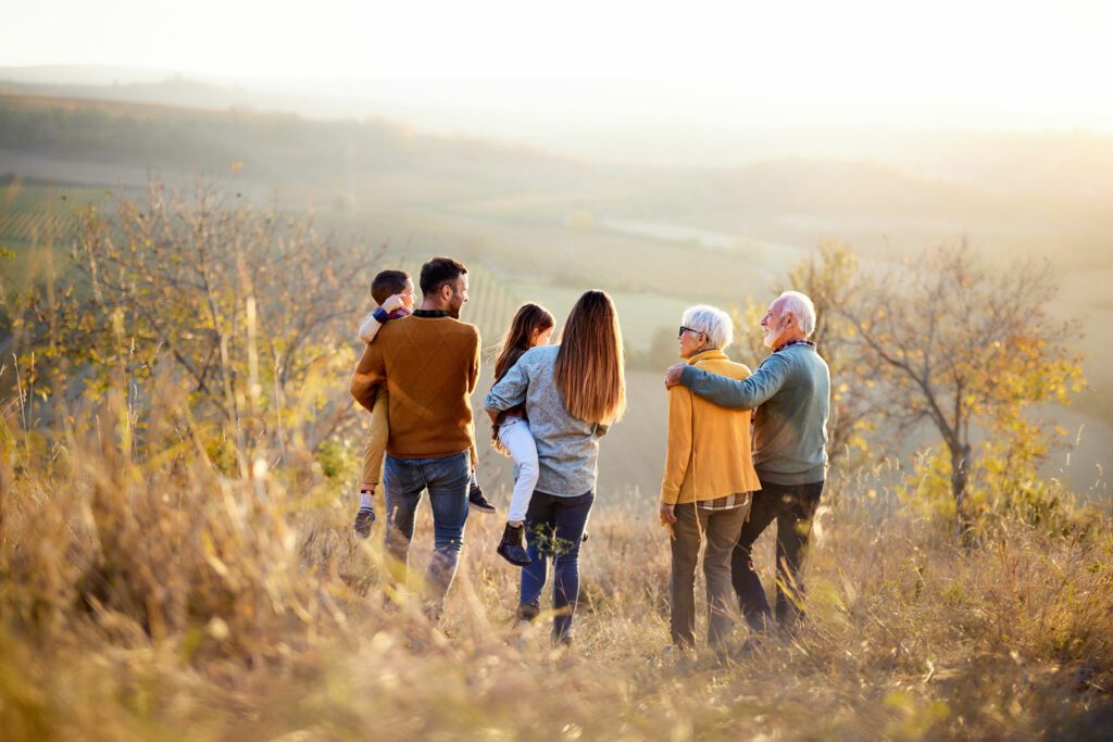 Back view of multi-generation family moving down the hill