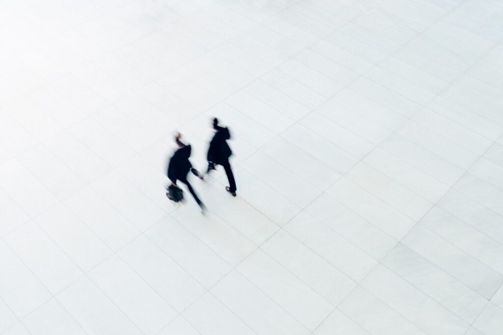 Overhead view of two businessman walking on large empty office.