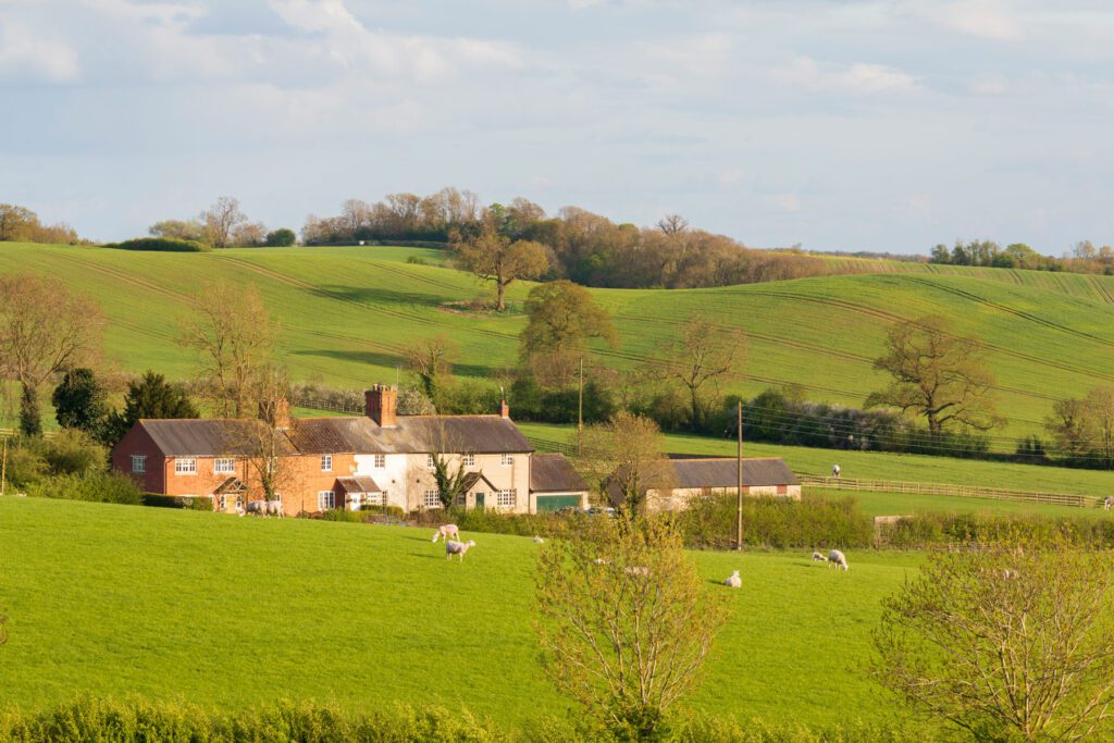 An image of a row of cottages and farmland near Loddington, Leicestershire, England, UK